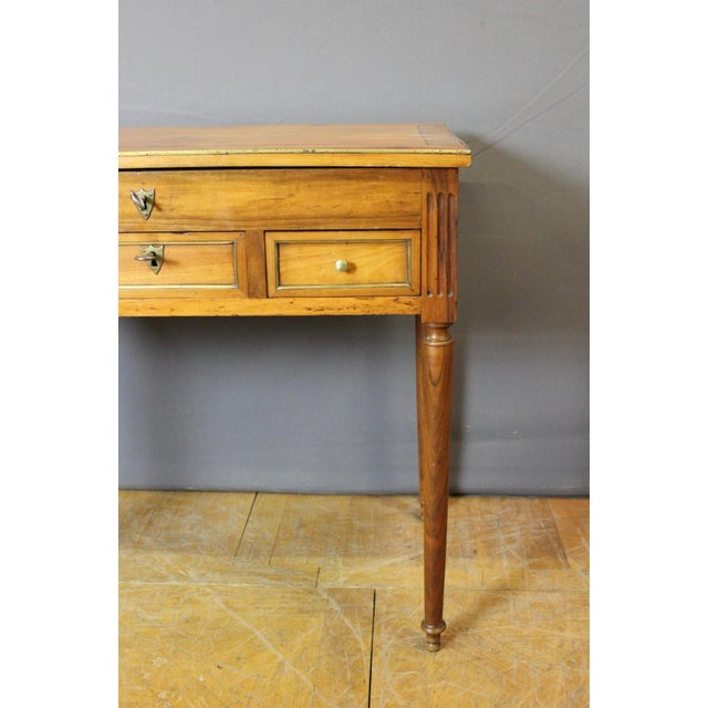 A Directoire period gentleman's dressing table in cherry wood, opening with three drawers and a drop-front revealing a...
