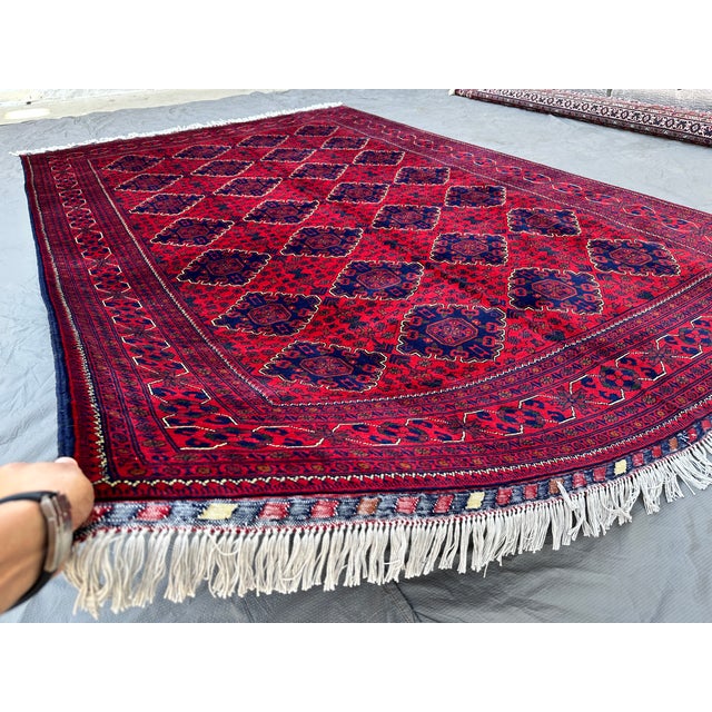 This finely woven Khamyab rug features a dense diamond lattice of octagonal medallions in deep navy, each centered with...
