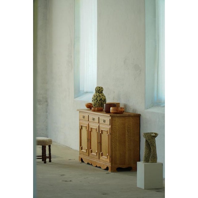 A beautifully crafted Danish sideboard cabinet in solid oak, produced during the 1970s. The cabinet features three paneled...