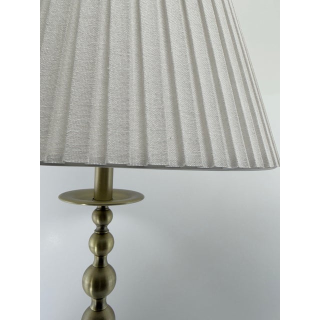 A refined pair of Ralph Lauren buffet lamps featuring a warm antique brass finish and elegantly turned ball-form stems....