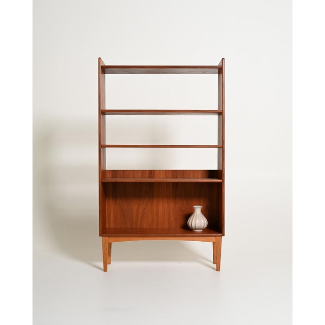 Teak frame with adjustable shelves and tapered solid wood legs. Original label present. Made by Bränntorps, 1950s-1960s....