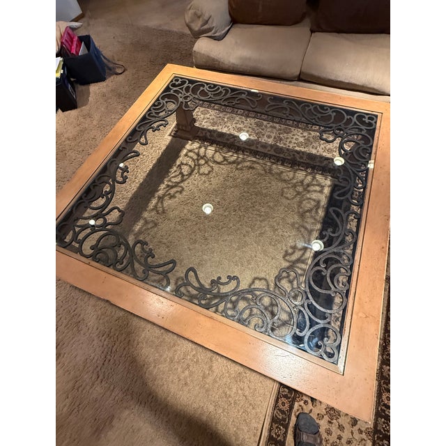 Purchased new in 2002 this beautiful square glass top wood frame coffee table has large wrought iron decorative scrollwork...