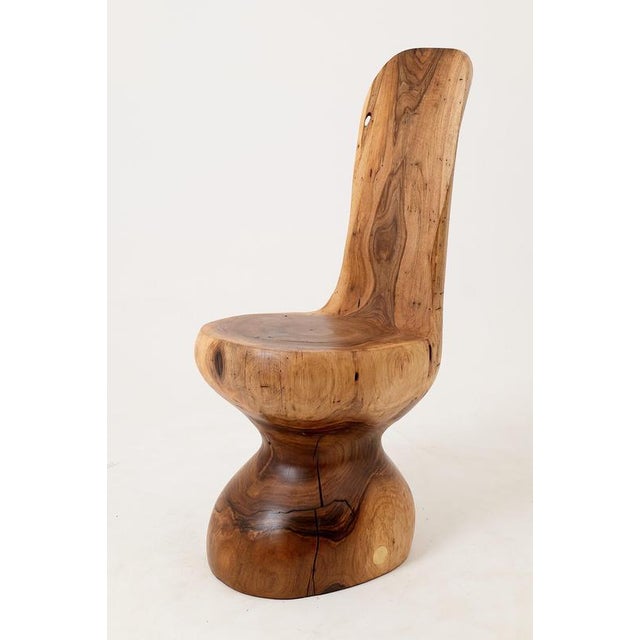 Few chairs can claim to be genuinely beautiful as objects. This one can. Carved from a single solid log, the form flows...