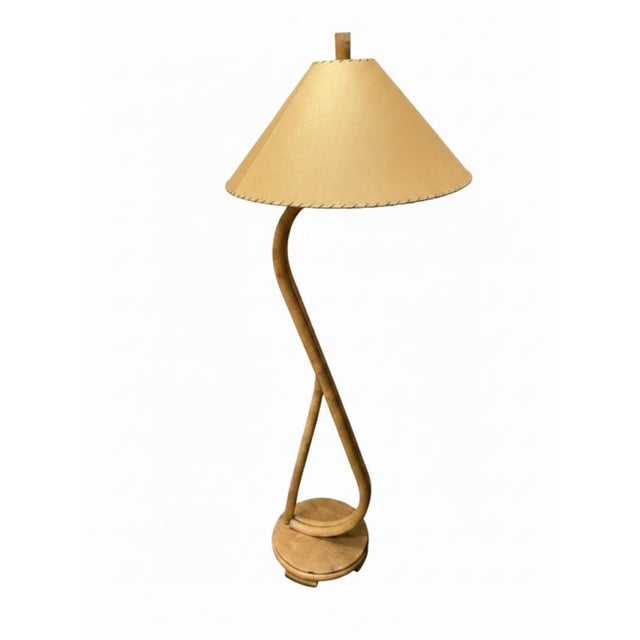 A striking vintage floor lamp featuring a sculptural bentwood and rattan frame with a graceful looping silhouette. The...
