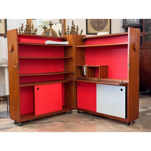 Mid century modern teak bar that closes into a neat cabinet on casters and opens out into an L shaped corner bar. Closed,...
