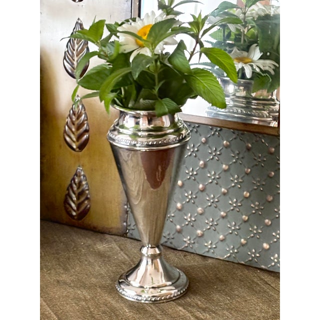 This elegant vintage silver-plated trumpet vase features a sleek, elongated silhouette measuring 8.5" H x 2.75" W....