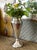 This elegant vintage silver-plated trumpet vase features a sleek, elongated silhouette measuring 8.5" H x 2.75" W....