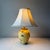 Vintage, custom, and refurbished yellow terracotta table lamp with patina'd brass accents. The lamp is paired with a...