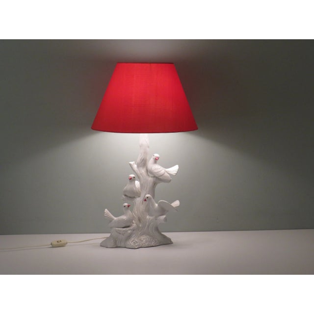 The lamp has a white glazed ceramic base with 4 doves on a branch and is fitted with a custom tangerine silky lampshade....