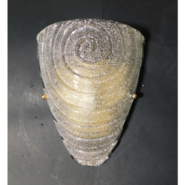 Italian wall light with a Murano glass shield hand blown in Graniglia technique to produce granular textured in a spiral...