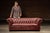 Handsome Chesterfield-style sofa upholstered in richly patinated oxblood-red leather. The substantial frame features a...