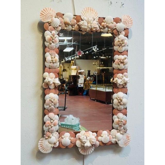 This large charming antique shell mirror showcases a beautifully hand-crafted frame adorned with an abundant arrangement...