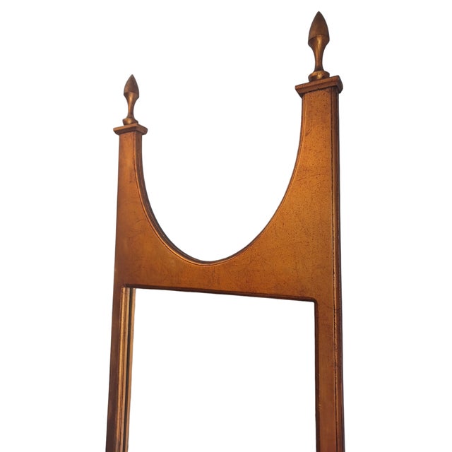 Vintage Hollywood Regency gtwood style mirror. Mirror is long and lean adorned by 2 finials .