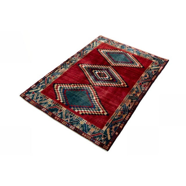 This expressive, hand-knotted Gabbeh nomad rug impresses with its powerful color palette and fascinating geometric...