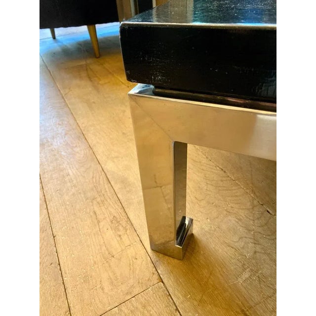 A large and substantial pair of side or end table in brushed steel with crackle finished black lacquered tops. By Guy...