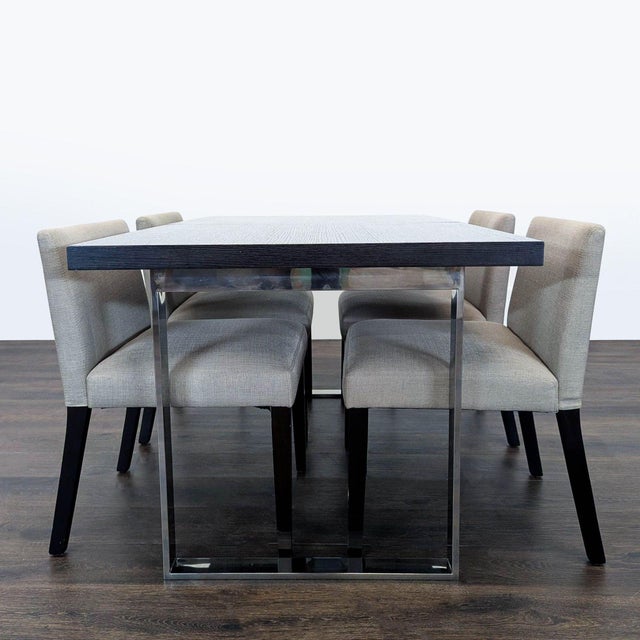 This EQ3 dining set includes a sleek rectangular table with leaf and a dark wood top and chrome legs, paired with four...