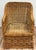 Classic vintage woven wicker lounge chair featuring braiding detail around the arms, back, and apron of the seat for a...