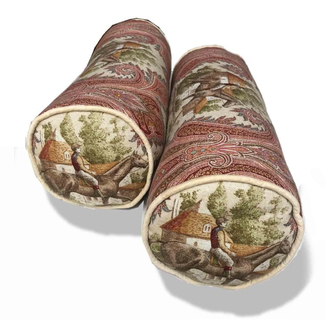 A pair of bolster cushions in P/Kaufmann toile fabric - horse jockey paisley design. Each is filled with down/feather...