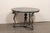 A French center table with serpent motif and green marble top. This vintage table from France features a round-shaped...