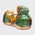 This petite ceramic figurine from the early 20th century fits in the palm of the hand, sculpted as a recumbent ram with...