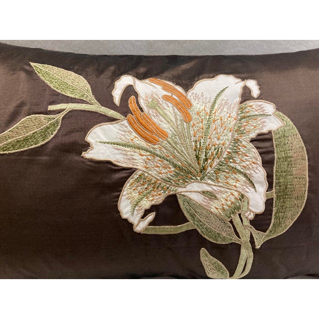 A lumbar pillow cover with a Lily floral embroidered motif . Note the embroidery colors are in ivory, apricot, olive on...