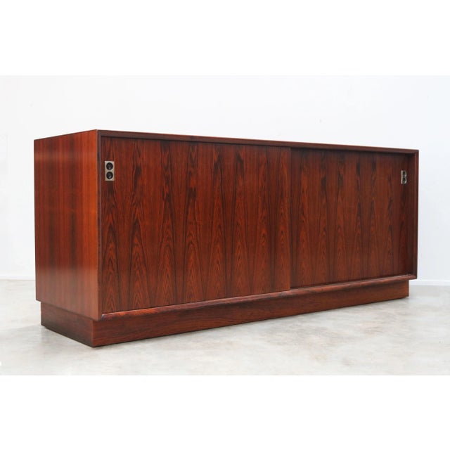 Experience the epitome of mid-century modern luxury with this Arne Vodder rosewood sideboard, featuring two sliding doors...