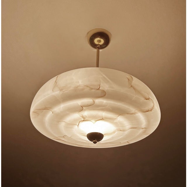 Art Deco pendant lamp from the 1930s, fully rewired, featuring a stepped pink mottled marble glass shade with darker...