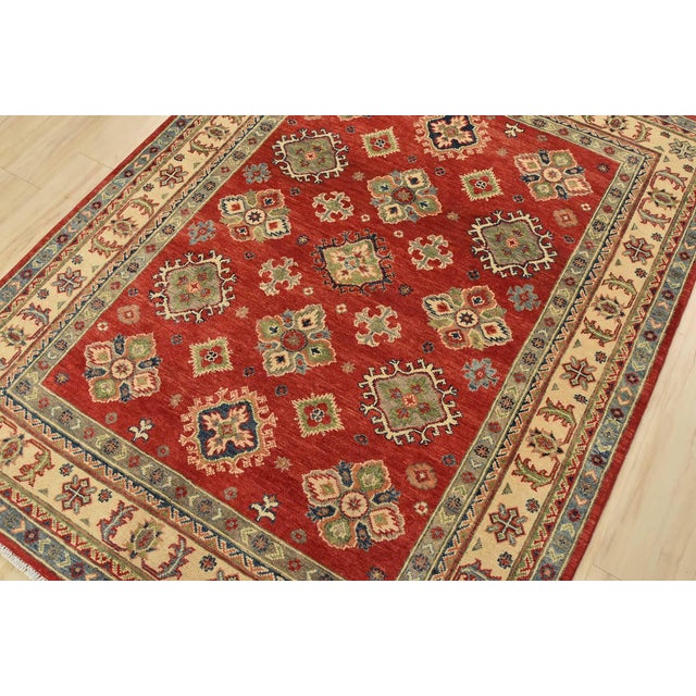 A tribal Caucasian Kazak rug hand-knotted with fine wool on a cotton foundation. This rug features geometric motifs set...
