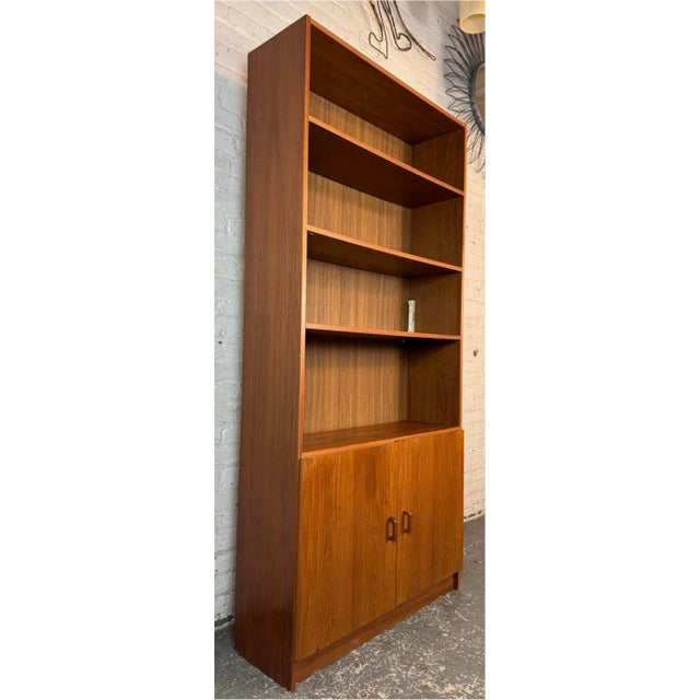 Danish teak veneer bookcase / storage cabinet with six levels of adjustable shelving, two of which are concealed behind...