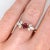 This beautiful ring features a 0.67 carat oval Mozambique Ruby gemstone with a natural earth mined diamond triad on both...