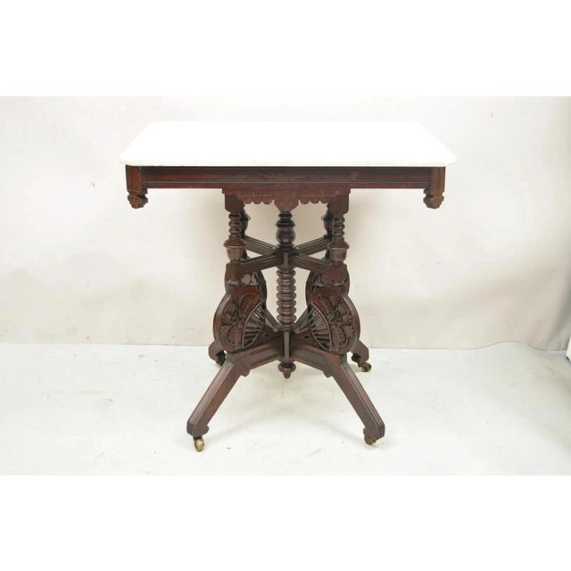 Antique Eastlake Victorian Floral Carved Walnut Marble Top Parlor Side Table. Item features an ornately carved base with...