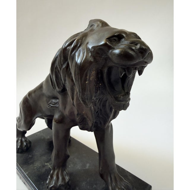Powerful bronze sculpture of a roaring lion, modeled with striking realism and dynamic tension. The composition conveys...