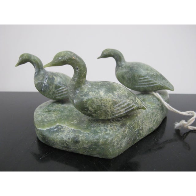 Canadian Inuit soapstone sculpture by Kawavow King, Frobisher Bay. 3 Green soapstone geese set upon a base. Each goose has...