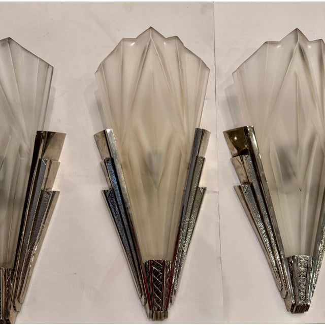 Set of four French Art Deco wall sconces by the French artist “Degue” in clear frosted glass shades with geometric motif....