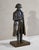 Brown patina bronze figure of Napoleon Bonaparte (1769-1821), wearing his famous bicorne hat, standing with his right hand...