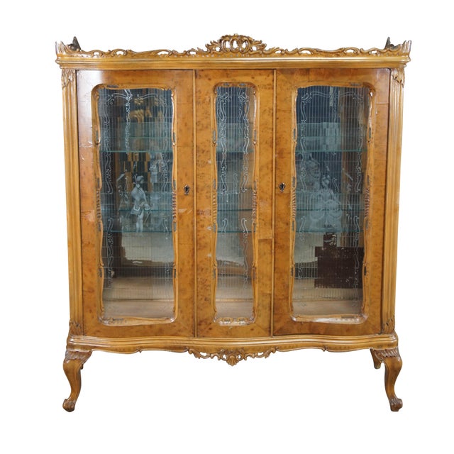 An exceptional Antique Italian Rococo Revival three-door vitrine display cabinet, masterfully crafted with striking,...