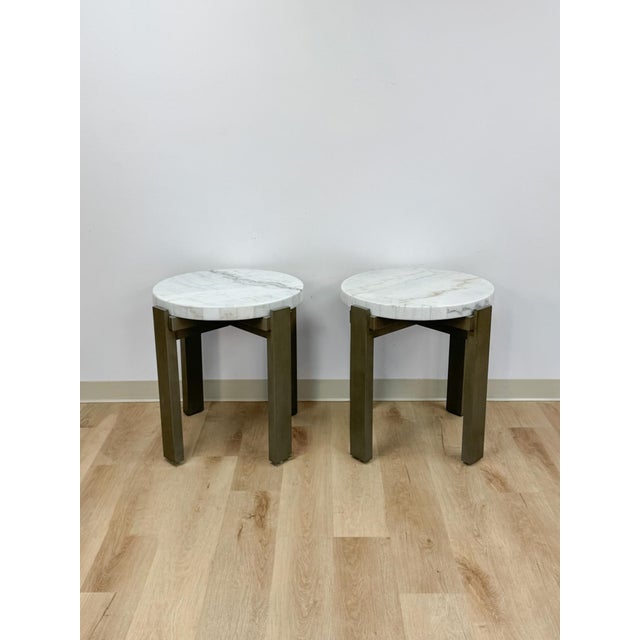 This clean and sophisticated pair of vintage beige marble top end tables with gray metal bases are a practical and good-...