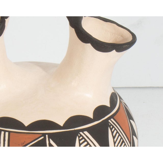 An Acoma Pueblo pottery wedding vase by the ceramicists Louis and Nadine Mansfield. This vase features a rounded body and...