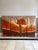 A dramatic and beautifully hand-painted 1970s triptych featuring a vivid sunset landscape rendered in warm gradients of...