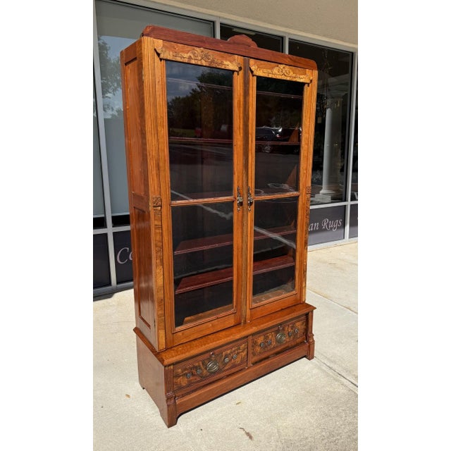 This 1920s Art Deco Mahogany and Burled Walnut Bookcase showcases elegant craftsmanship with its glass-paneled doors,...