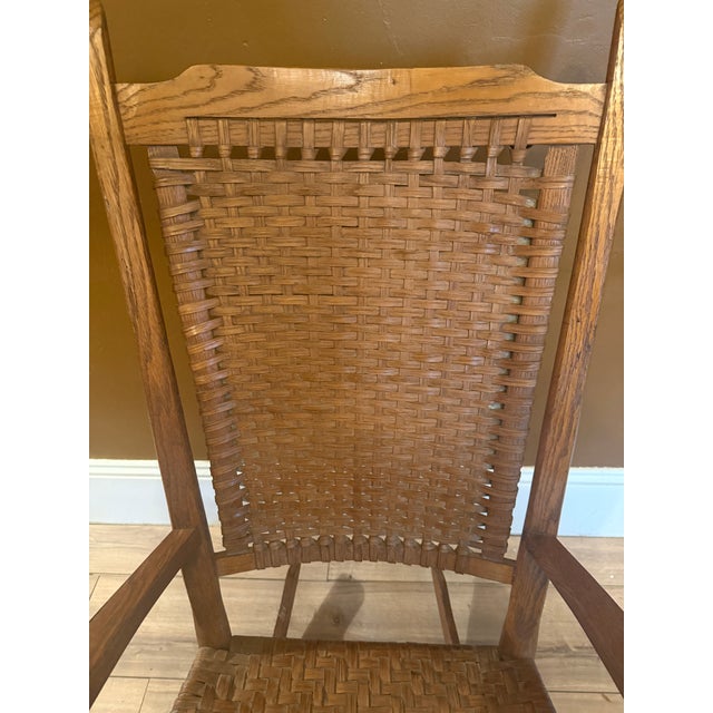 Oak rocking chair with a hand-woven splint herringbone seat and basket-weave back with wrapped rails. Wide paddle arms and...