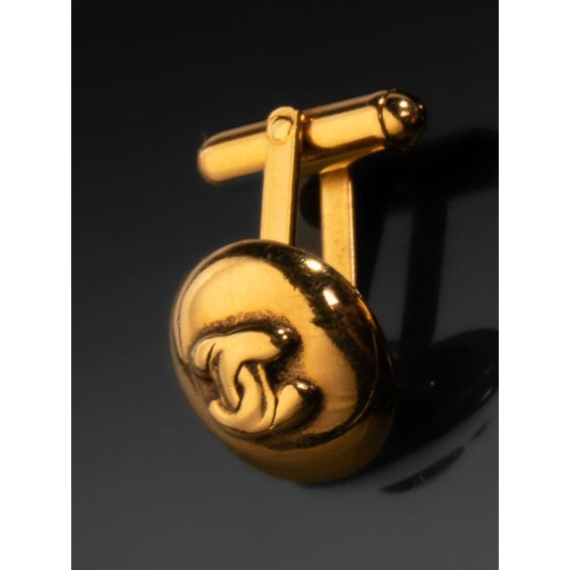 A refined pair of vintage Chanel handle-style buttons crafted in gilded metal, each featuring the iconic interlocking "CC"...