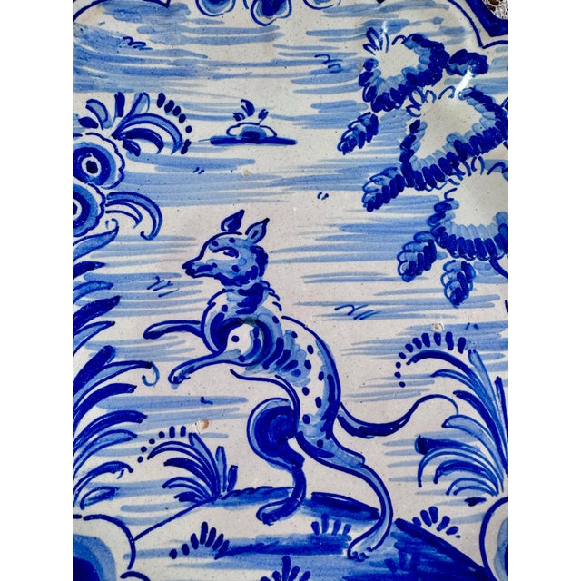 A charming vintage Spanish Talavera-style ceramic wall plate, hand-painted in traditional cobalt blue and white with a...