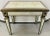 A Hollywood Regency style eglomise mirrored side table. The table top features a fine gold yellow paint design with a...