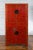 A Chinese Qing Dynasty period red lacquered cabinet from the 19th century with four doors, two drawers and hand-painted...