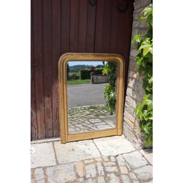 Louis Philippe mirror, 19th century. Its frame is entirely gilded with gold leaf. It has a beautiful and luminous patina....