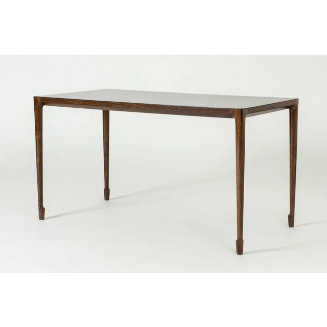 Elegant rosewood coffee table by Bernt Petersen, with a smooth top. Amazing slender design with beautifully sculpted feet.
