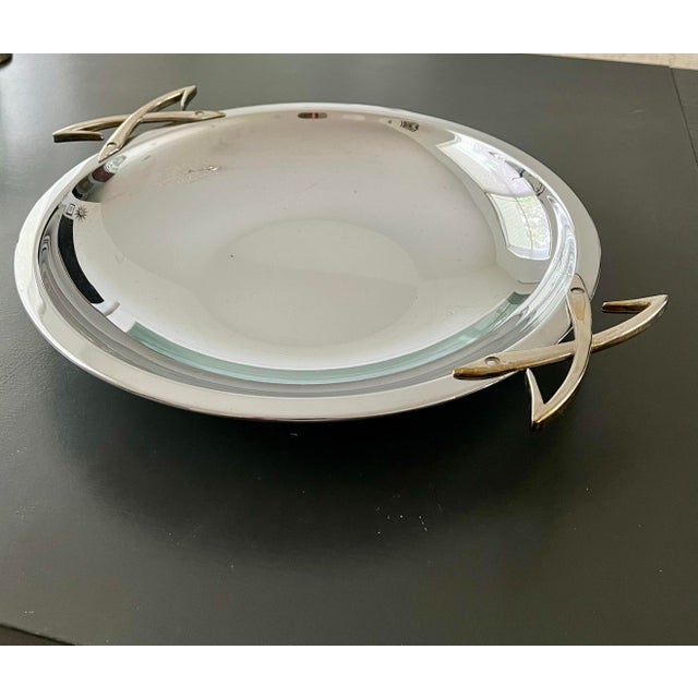 I love the shape of this look MCM server. Its pleasing round chrome bowl is modern and shiny. The unusual cross handles...