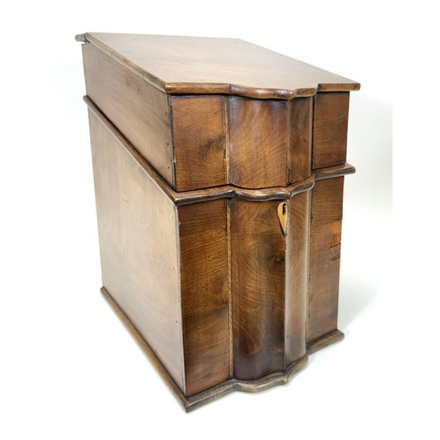 This 19th century mahogany knife box features a serpentine front and slanted lid, crafted in a rich, warm-toned veneer....