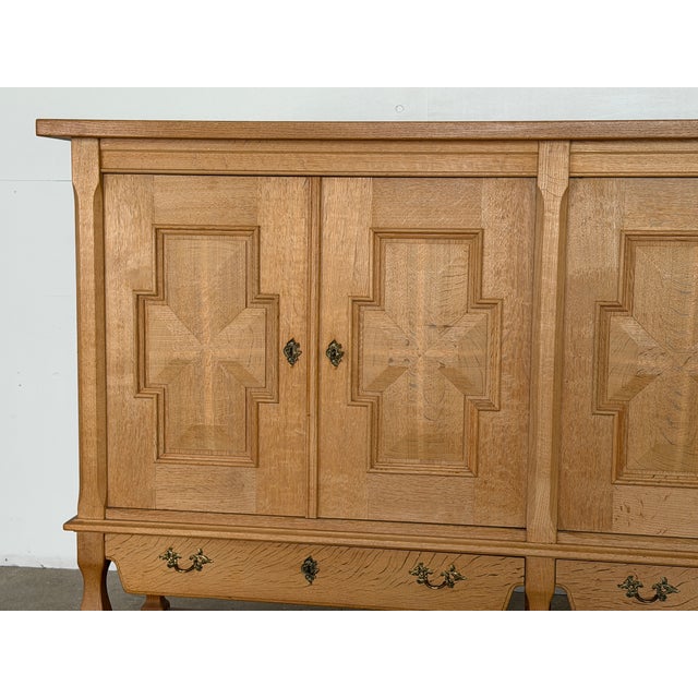 A highly sculptural Danish oak sideboard designed by Henning (Henry) Kjærnulf and produced by Nyrup Møbelfabrik in the...